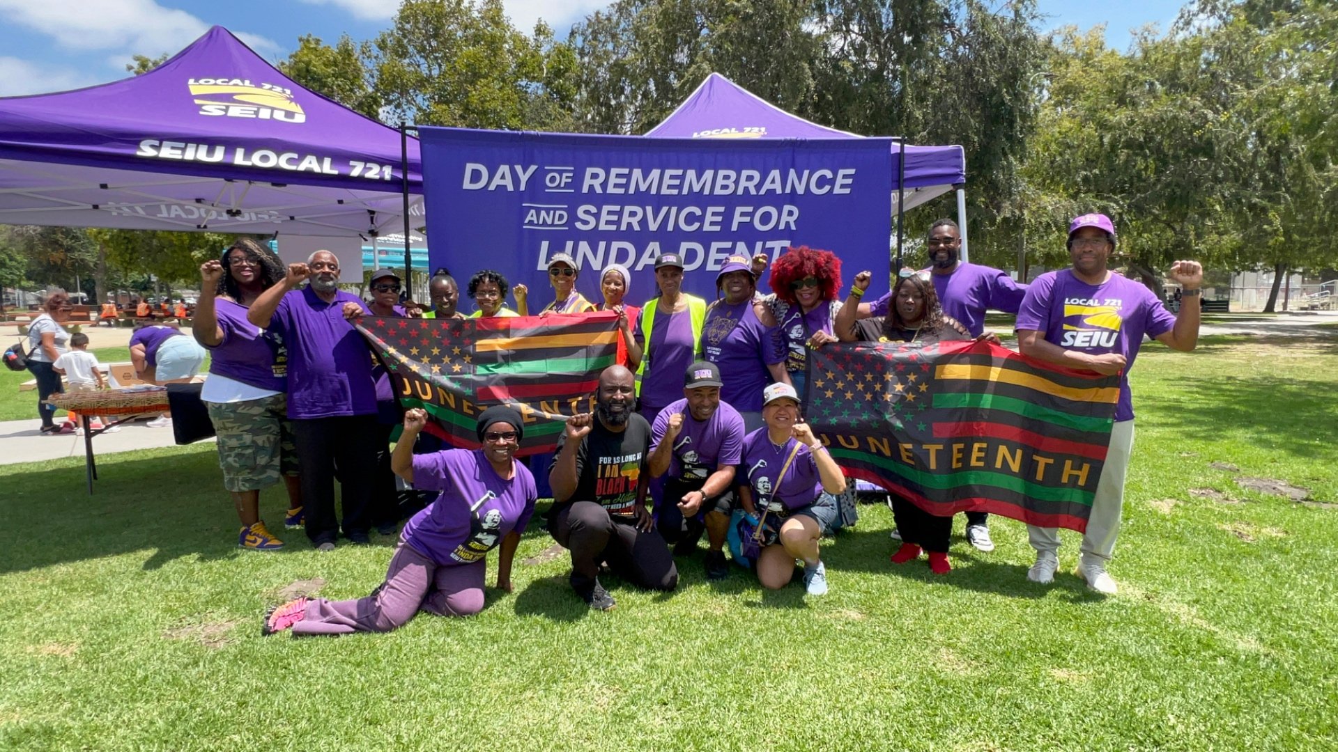 SEIU 721 members gathered at the Day of Remembrance and Service for Linda Dent, holding Juneteenth flags in front of an SEIU Local 721 tent