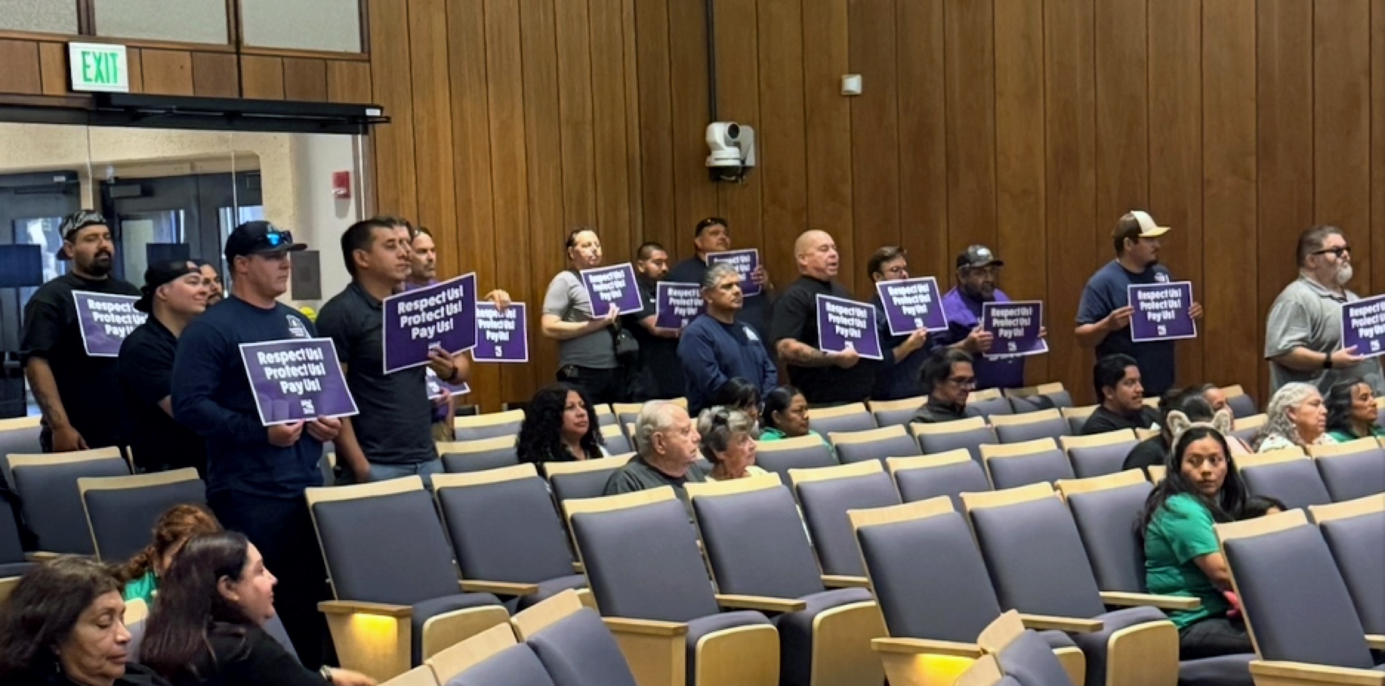 Santa Ana members hold signs at council chambers