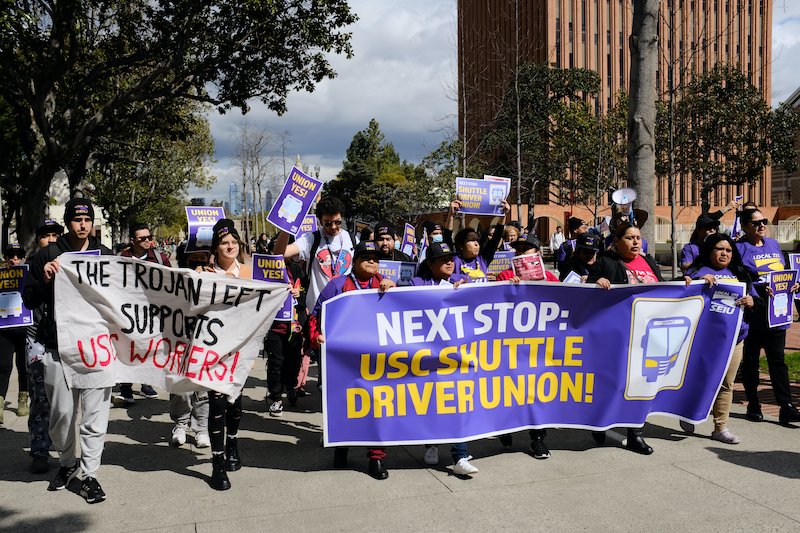 Photo of USC students and shuttle drivers marching through USC campus